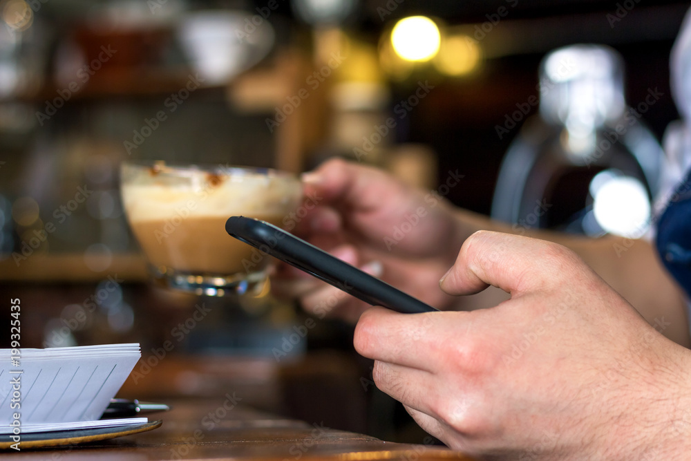 Human hand holding mobile phone blank screen touching in coffee shop