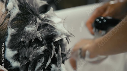 Close-up of a young caucasian man having his hair washed in a hairdressing salon