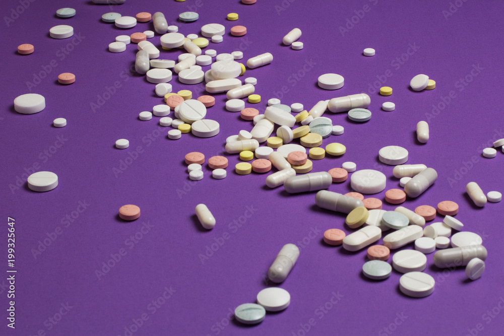 Tablets scattered on a violet background. Tablets scattered on a violet background.