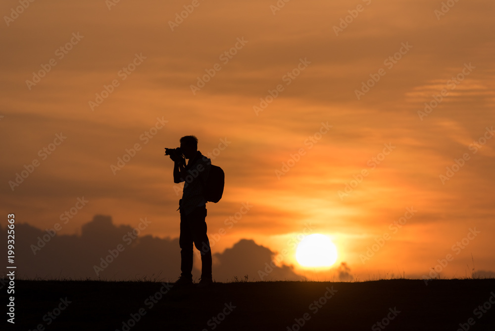 silhouette Photographer stand on the hill and mountains at sunset time silhouette Photographer stand on the hill and mountains at sunset time