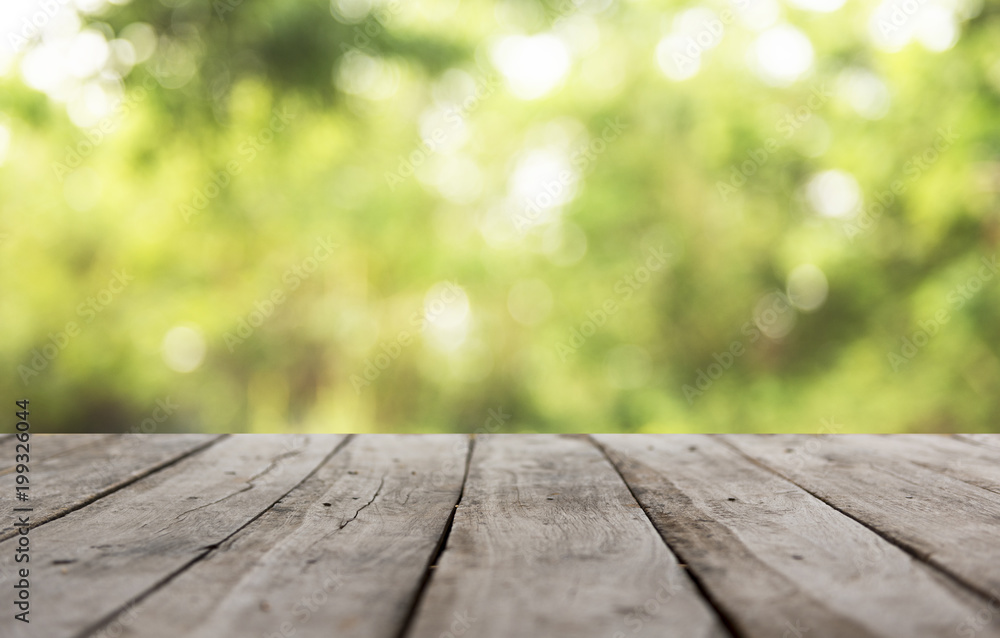 Wood plank with abstract natural green blurred bokeh background for product display Wood plank with abstract natural green blurred bokeh background for product display