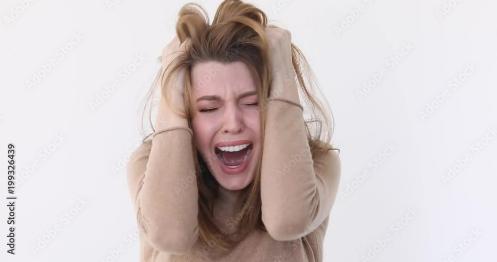 Close up of a young stressed girl shouting isolated white wall background Close up of a young stressed girl shouting isolated white wall background