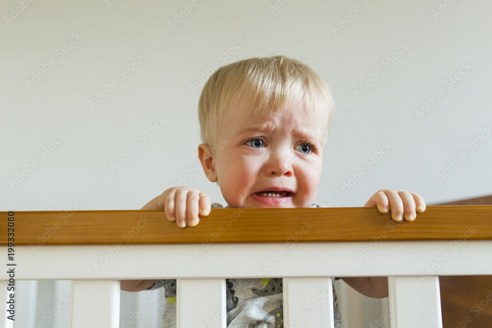 Baby boy crying while standing in crib Baby boy crying while standing in crib