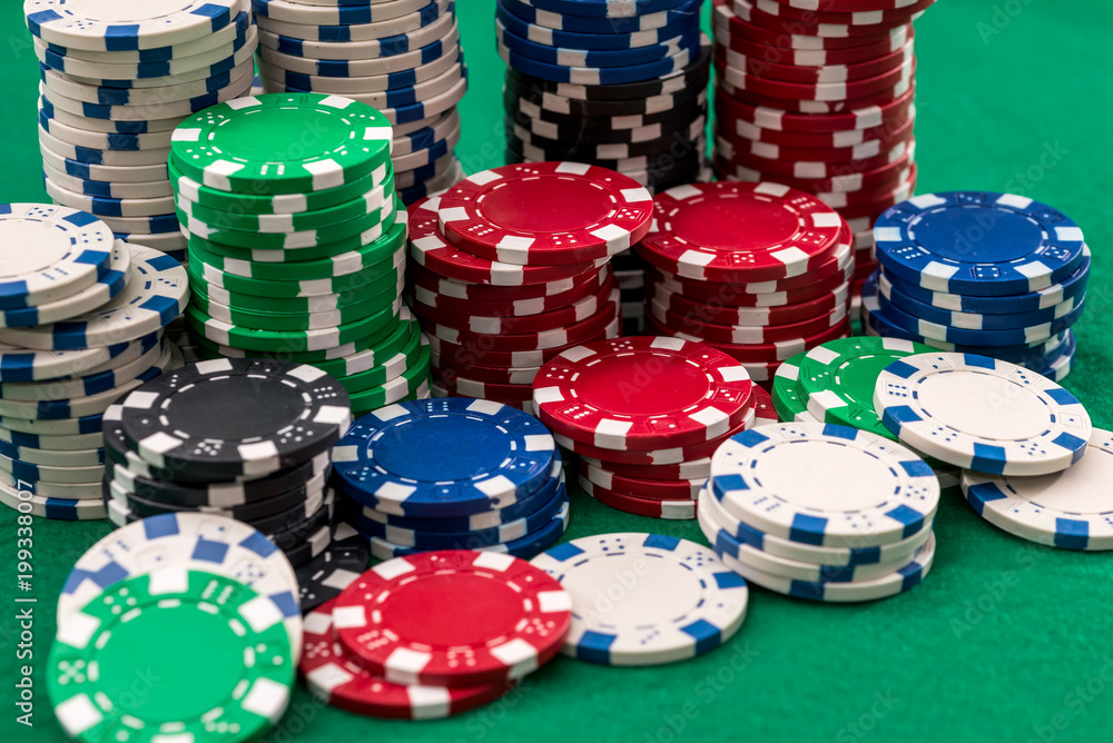 many poker chips isolated on a green background many poker chips isolated on a green background