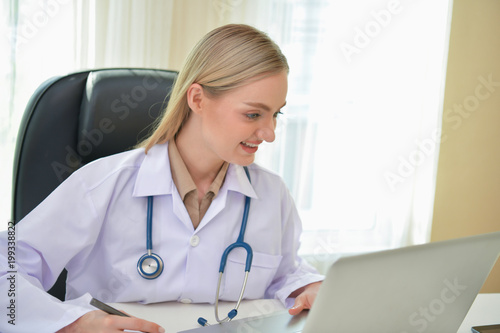 Doctor Concept. Smiling doctor posing in the office. Young doctor is wearing a stethoscope. medical staff on the hospital background. The doctors are happy to work.