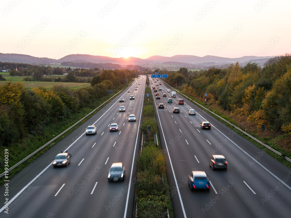 Obraz premium The road traffic on a motorway at sunset