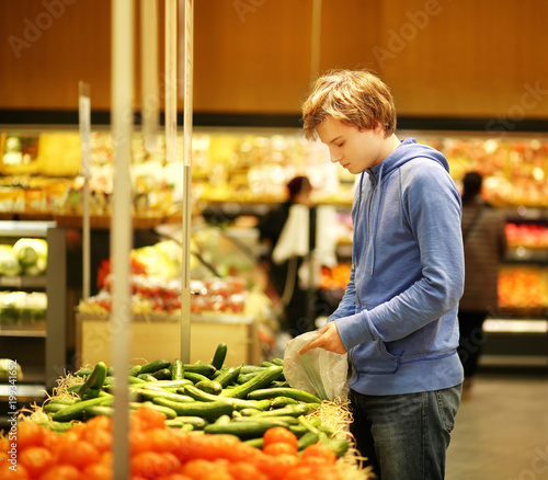 Young man buying vegetables at the market
