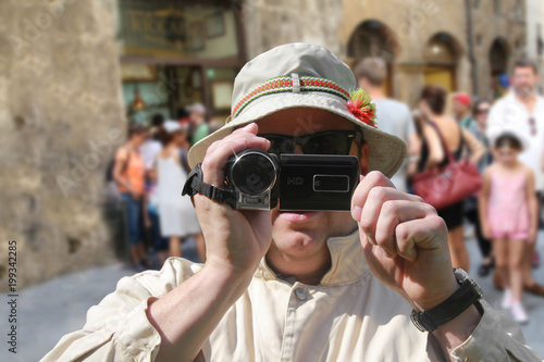 Tourist mit Videokamera und Sonnenhut photo