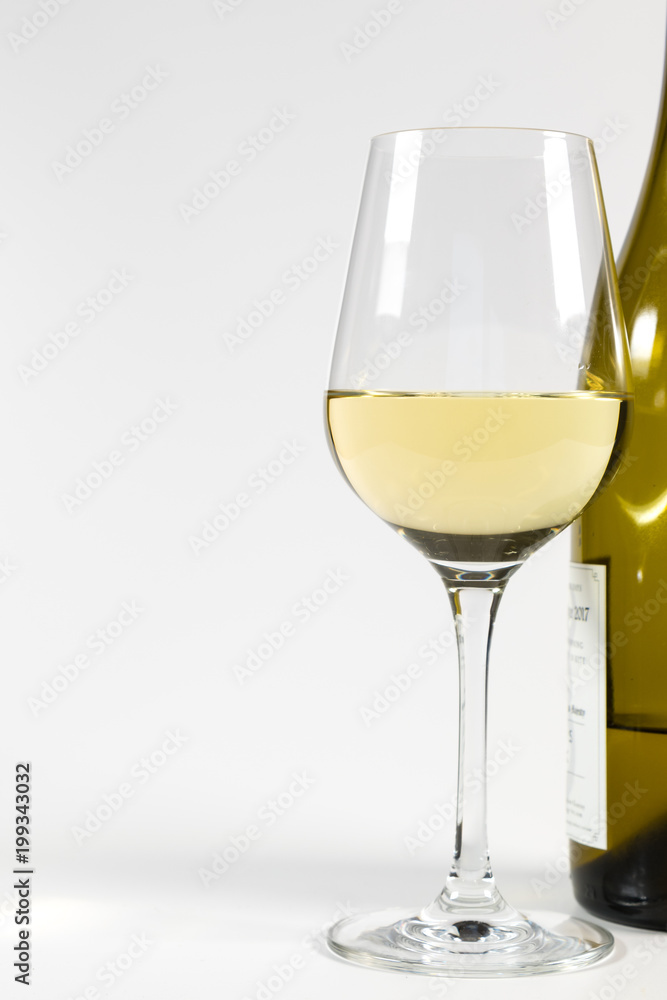 Ein Glas Weisswein und eine Flasche Wein auf weißem Hintergrund Ein Glas Weisswein und eine Flasche Wein auf weißem Hintergrund