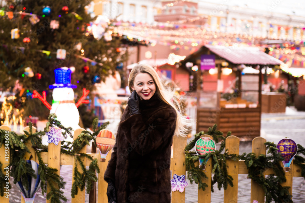 Portrait in full growth, Russian beautiful woman in a mink coat on the Red Square in Moscow in Christmas time