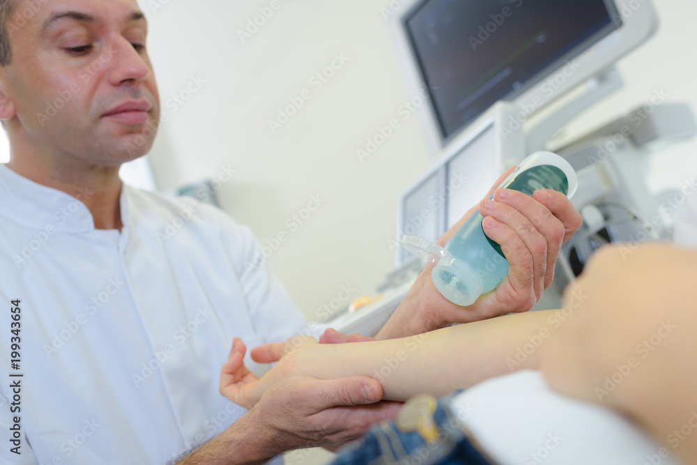 Doctor squirting get onto patient before scanning Doctor squirting get onto patient before scanning