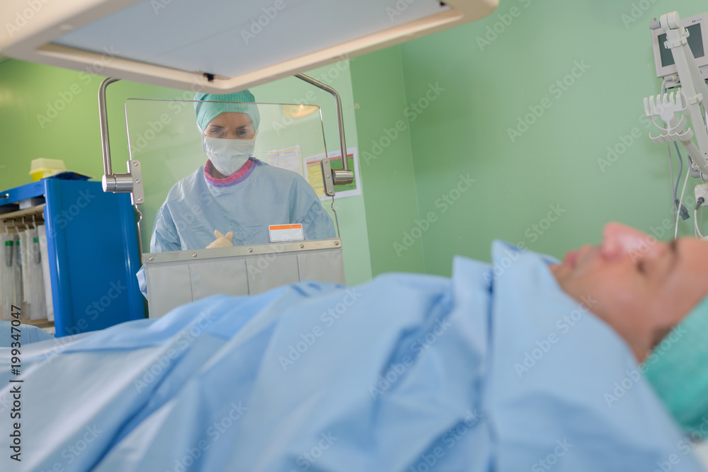 doctor waiting behind screen as patient gets x-ray doctor waiting behind screen as patient gets x-ray