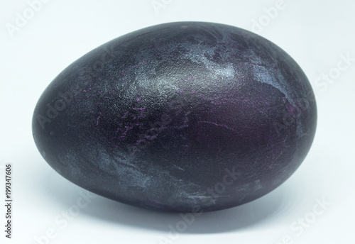 Theme Easter. Close-up of a duck egg stained in dark shades of violet.