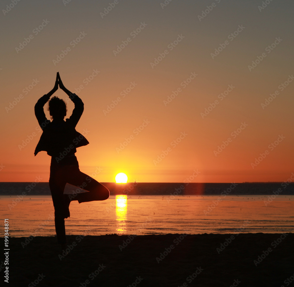 Posture zen au coucher de soleil en bord de mer