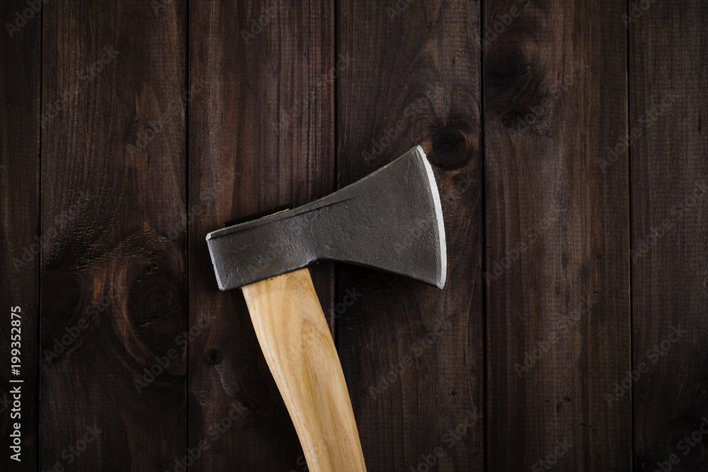 Closeup lumberjack axe on dark wooden background