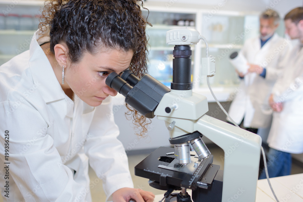 Female scientist looking into microscope Female scientist looking into microscope