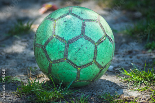 green soccer ball lies on the ground. photo