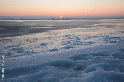 Frozen sea on sunset. Beautiful natural seascape on winter time. Endless ice to horizon. Ice surface for product placing.