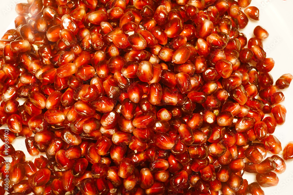 Pomegranate grain scattered on white background, top view. Pomegranate grain scattered on white background, top view.