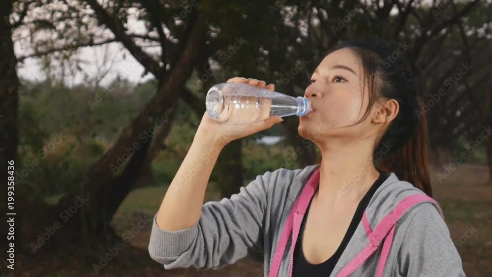 slow motion of young sporty woman drinking water in the park slow motion of young sporty woman drinking water in the park