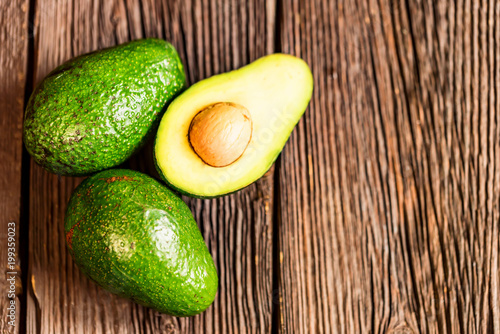 Avocados cut and whole on a wooden background
