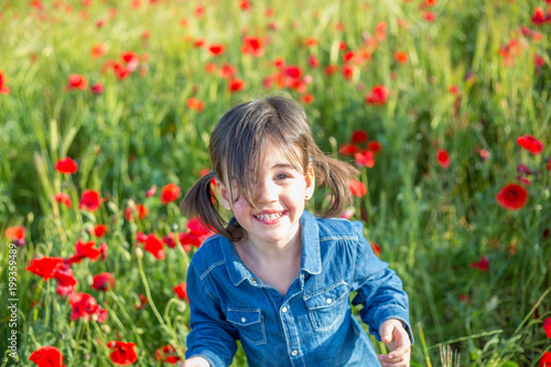 little girl posing in field of poppies