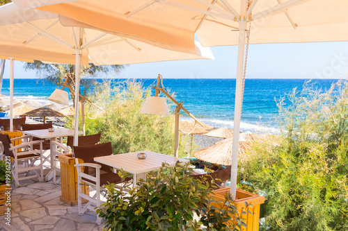 Fototapeta Naklejka Na Ścianę i Meble -  restaurant terrace in front of the beach in kamari on the island of santorini