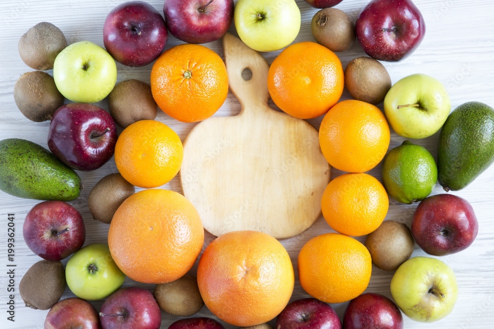 Set of raw fruits with wooden board on white wooden background. Top view. Flat lay. Set of raw fruits with wooden board on white wooden background. Top view. Flat lay.