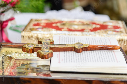 The decorated wooden Cross, the prayer book, the icon and the Bible lie on the altar in the Christian temple