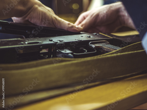 Photography man disassemble rifle close up on the table
