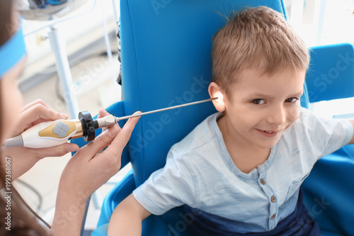 Otolaryngologist examining little boy's ear with ENT telescope in hospital. Hearing problem