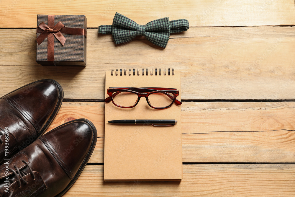Flat lay composition with shoes, notebook, tie and gift box on wooden background. Father's day celebration Flat lay composition with shoes, notebook, tie and gift box on wooden background. Father's day celebration