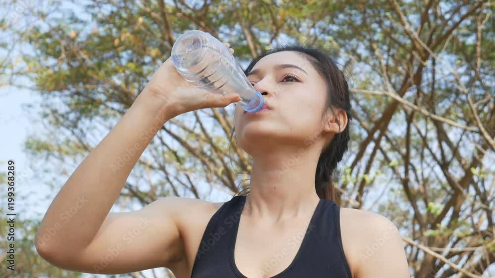 slow motion of young sporty woman drinking water in the park slow motion of young sporty woman drinking water in the park
