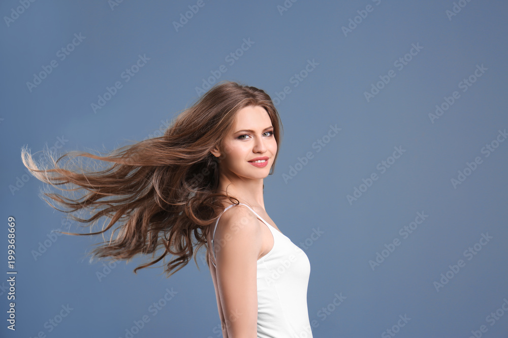 Portrait of young woman with long beautiful hair on grey background Portrait of young woman with long beautiful hair on grey background