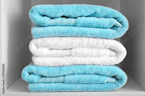 Stack of clean towels on shelf