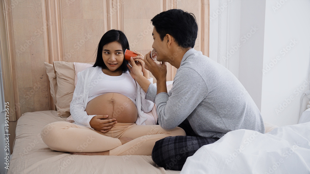 The parent talking and playing with can phone on belly pregnant The parent talking and playing with can phone on belly pregnant