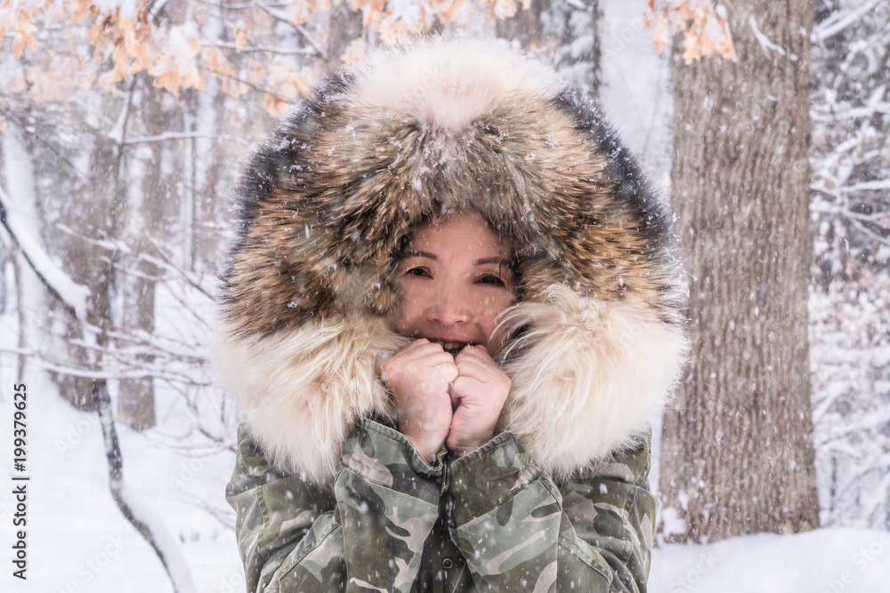 An Asian woman is enjoying winter snowstorm day An Asian woman is enjoying winter snowstorm day