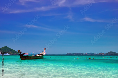Landscape with wooden fishing longtail boat at noon tropical sea with turquoise water. Seascape Concept of aboriginal life in Asia © Konstantin