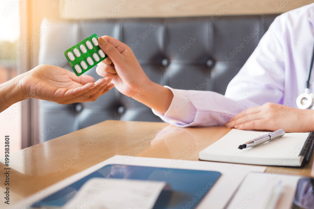 Fototapeta premium doctor hand holding tablet of drug and explain to patient in hospital room.