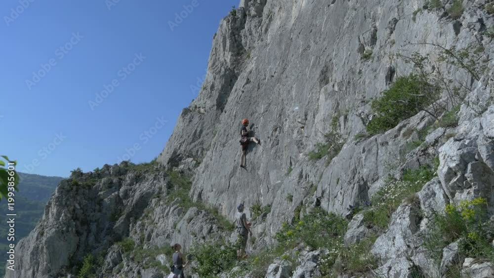 Tilt view of people rock climbing Tilt view of people rock climbing