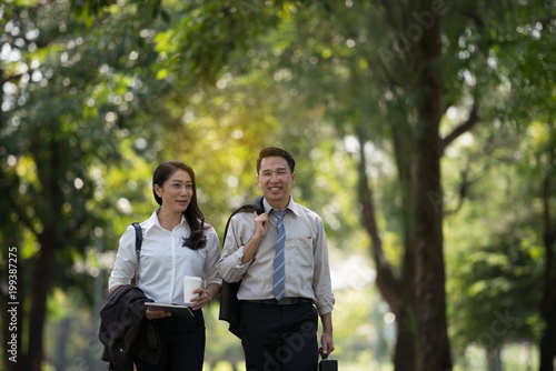 Young Asia businessman and woman happy face. He was walking in the Park.