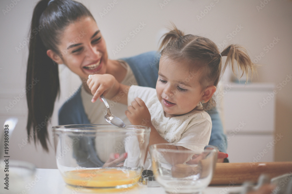 Mother and her little girl baking cookie together. Close up. Mother and her little girl baking cookie together. Close up.