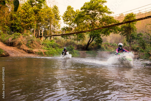 Blurred image enduro motorcycle racer drove into the water