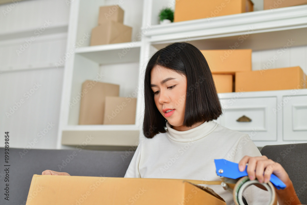 Sme business concept. Young Asian people are packing their packages.Delivery business Small and Medium Enterprise (SMEs). Young man is working in the house.Young Owner Start up for Business Online. Sme business concept. Young Asian people are packing their packages.Delivery business Small and Medium Enterprise (SMEs). Young man is working in the house.Young Owner Start up for Business Online.