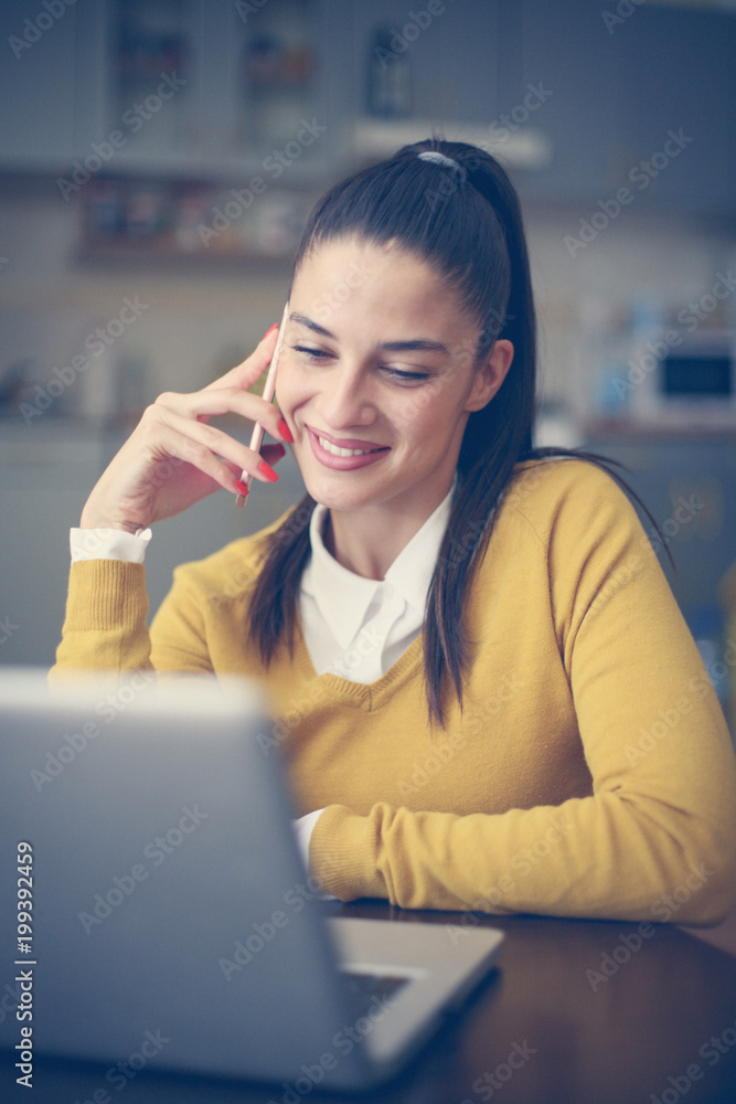 Woman using laptop and talking on smart phone. Woman using laptop and talking on smart phone.