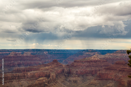 Skyline above the grand canyon. Beautiful Grand Canyon shapes under the dark stormy clouds with rain somewhere in the far horizon.