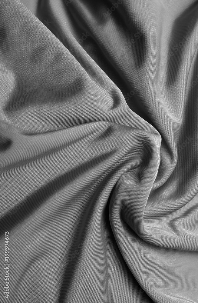 Background of fabric, twisted folds on a textured gray fabric.