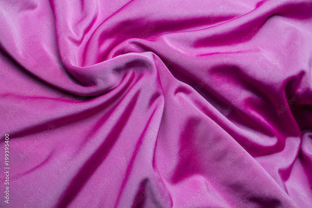 Fototapeta premium pink fabric with folds in relief. twisted reflective with a texture synthetics effect of silk.