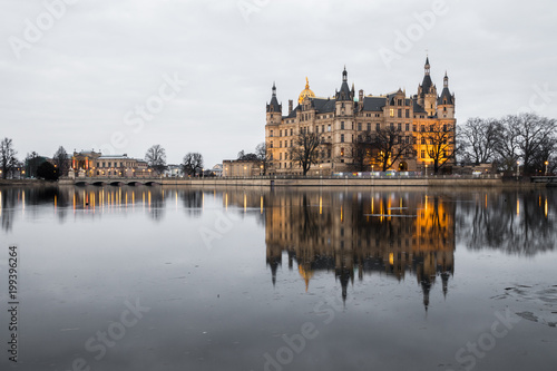 Sunset at Schwerin Castle Palace (Schweriner Schloss), reflected in the water of Schweriner See lake. World Heritage Site in Mecklenburg-West Pomerania, Germany