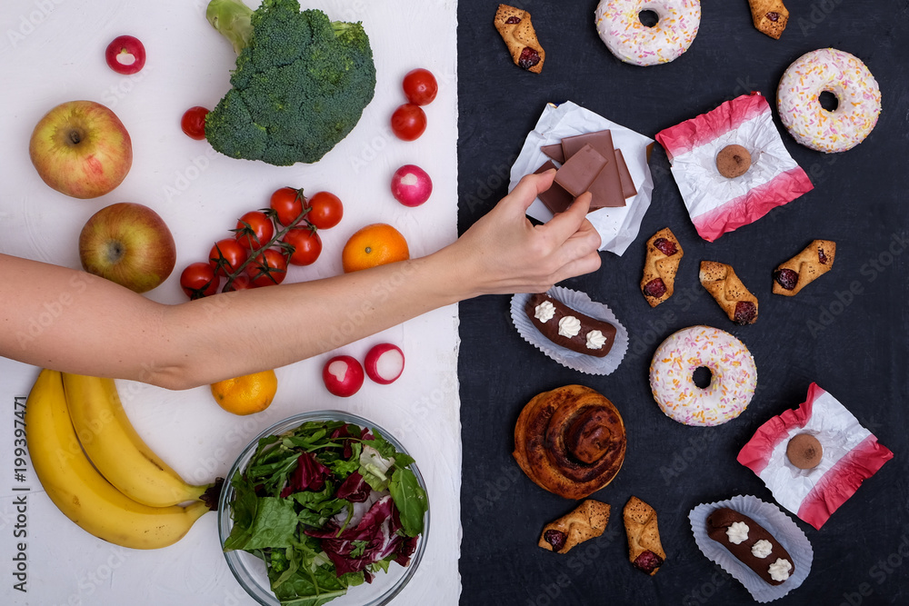 Concept photo of healthy and unhealthy food. Fruits and vegetables vs donuts,sweets and burgers